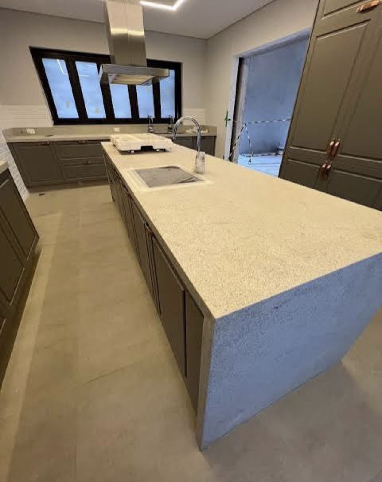 Ilha de cozinha em quartzo branco, com cuba e cooktop integrados